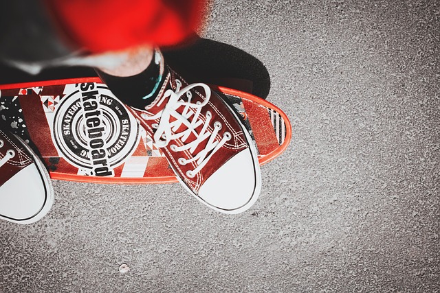Picture of person's trainers and lower legs on top of a skateboard