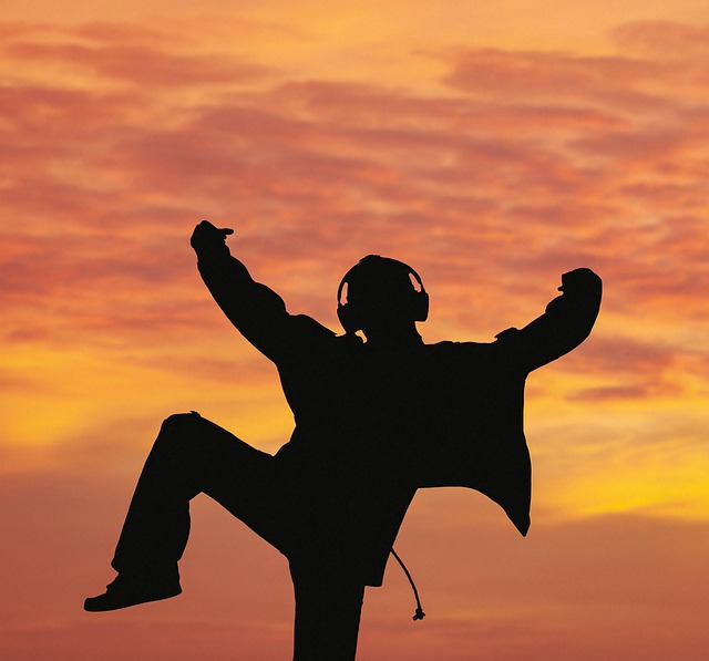 Picture of silhouette of person dancing with headphones on.