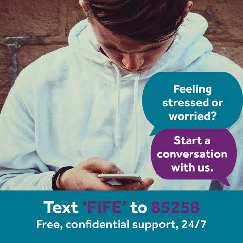 Picture of a person looking at their mobile phone. Text states. Shout text service. feeling stressed or worried? start a conversation with us. Text Fife to 85258. Free confidential support 24/7.